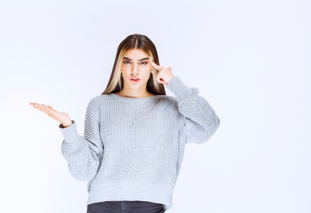 Girl in grey shirt looks confused and thinking.