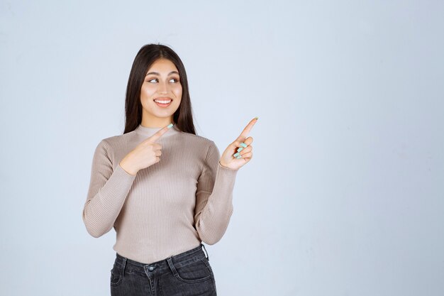 Girl in grey shirt showing something above and getting excited.