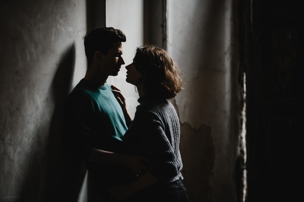 Girl and guy stand one opposite the  other and lovely look at each other
