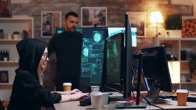 Free Photo girl hacker wearing glasses and a hoodie while stealing personal data with her team.