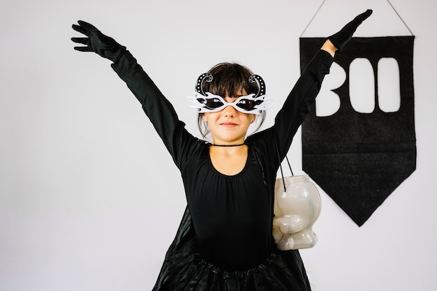 Girl in Halloween costume holding hands up