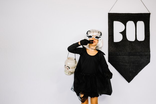 Girl in Halloween costume showing victory sign