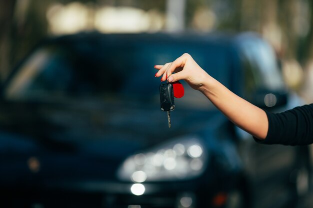 Girl hands with key of new car