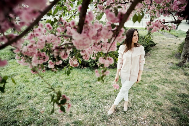 Girl has dreamy look and stands among a park