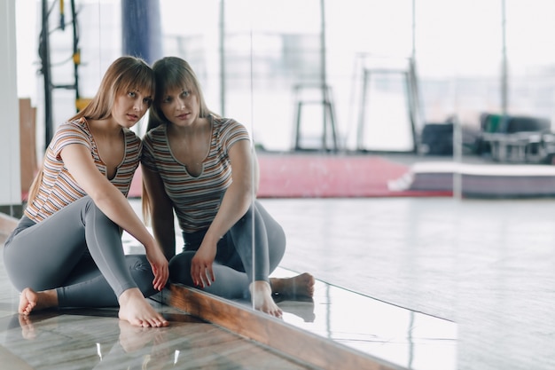 Girl have a rest on the floor near the mirror