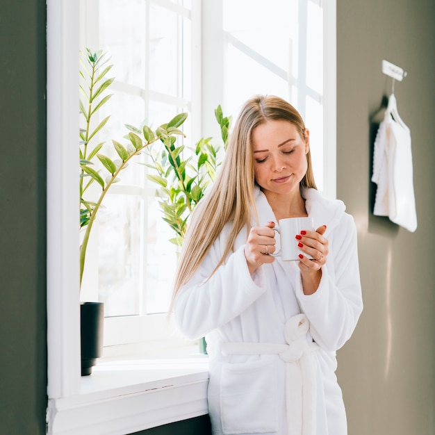 Girl having coffee at the bathroom