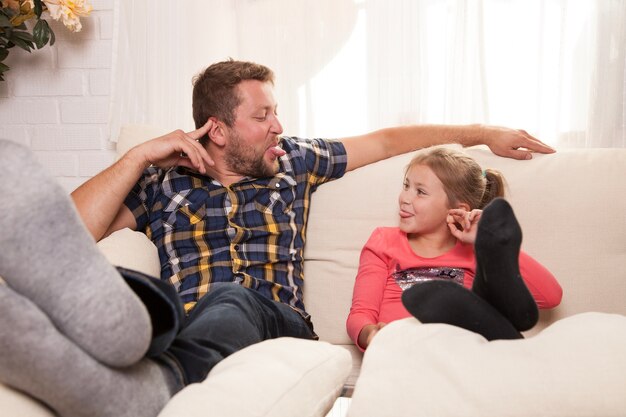 Girl having fun with her father at home