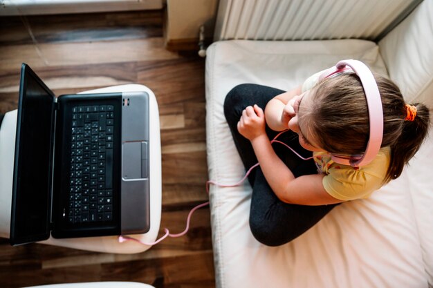 Girl in headphones wathcing movie on laptop