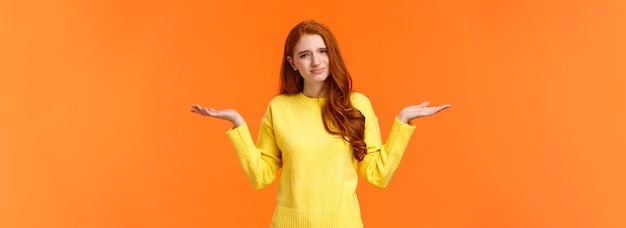 Free photo girl hearing ridiculous stupid question careless and unbothered cute redhead woman in yellow sweater