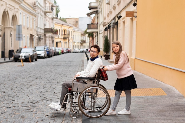 Free Photo girl helping disabled man traveling in the city