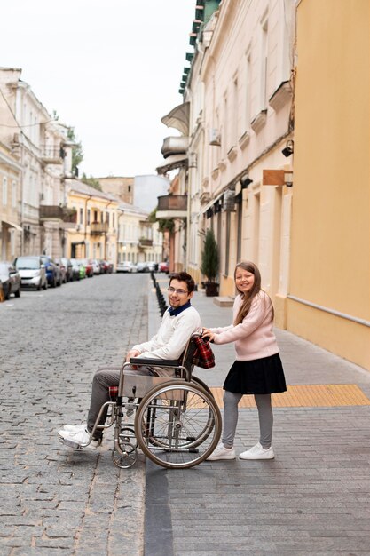 Girl helping disabled man traveling in the city