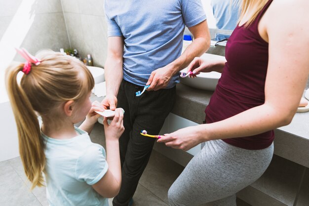 Girl helping parents with toothpaste