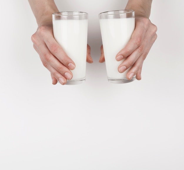 Girl holding 2 glasses of milk