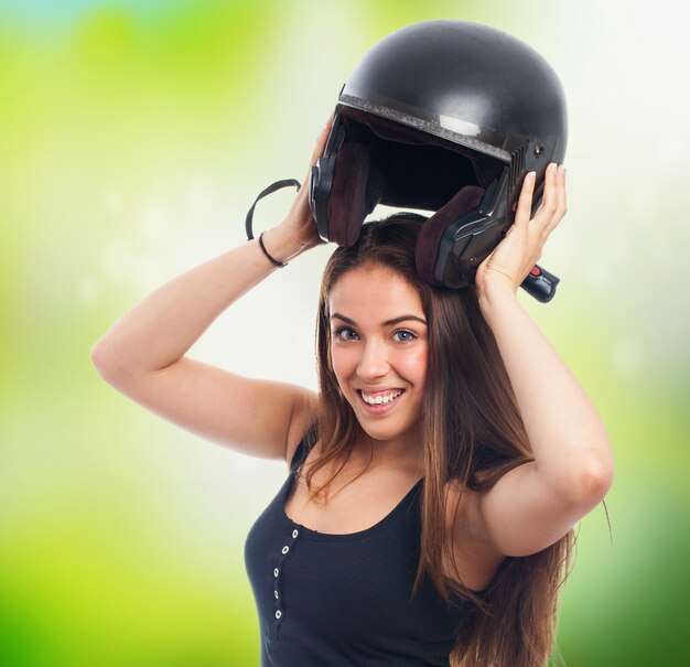 Girl holding black helmet under head.