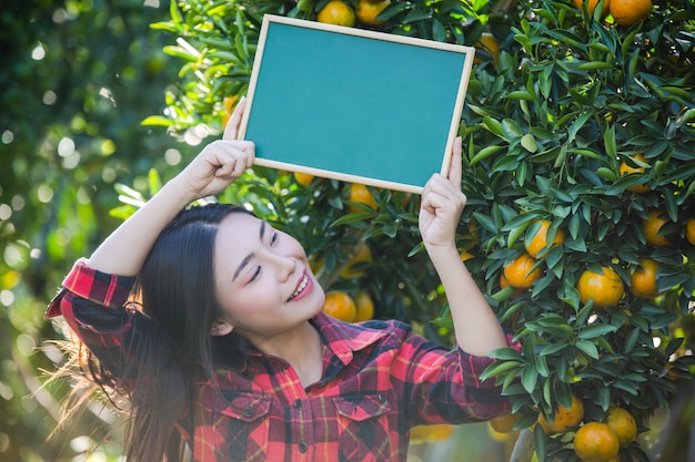 Girl holding blank small greenboard