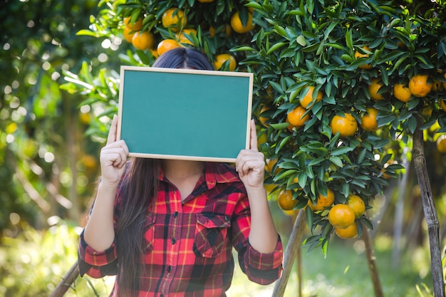 Free photo girl holding blank small greenboard