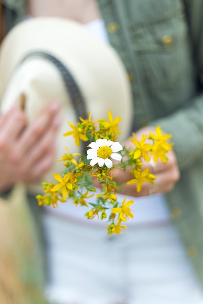 Girl holding a bouquet yellow flowers in the park.