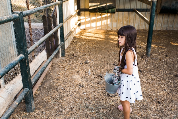 Free photo girl holding bucket standing in the field