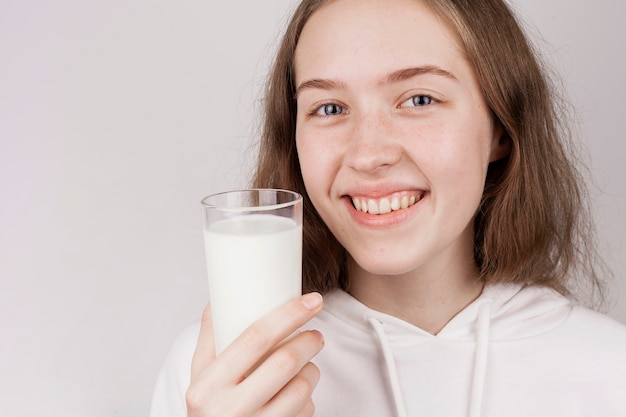 Free photo girl holding a glass of milk close-up