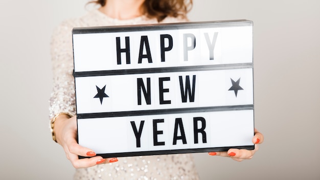 Free Photo girl holding happy new year sign