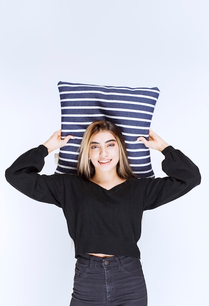 Free photo girl holding her blue striped pillow and sleeping.