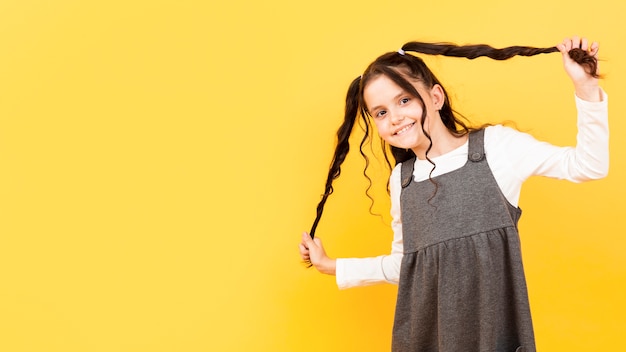 Girl holding her pigtails copy-space