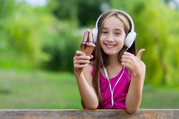 Girl holding ice cream giving thumbs up