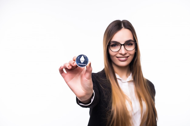 Girl holding a physical Ethereum coin cryptocurrency in her hand