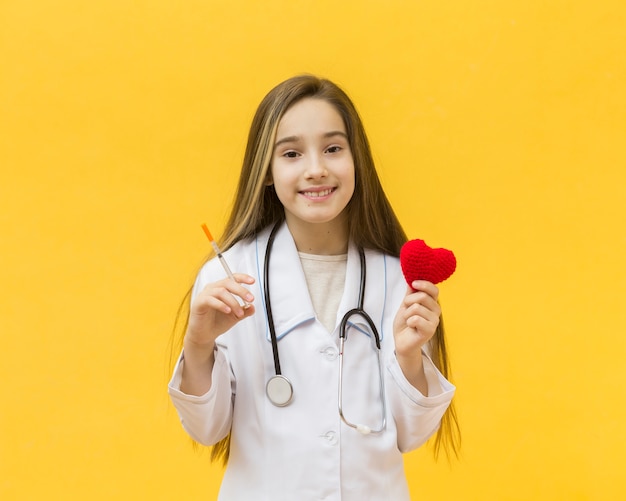 Free Photo girl holding syringe and heart