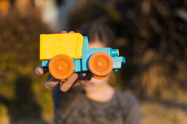 Free photo girl holding toy car in front of her face