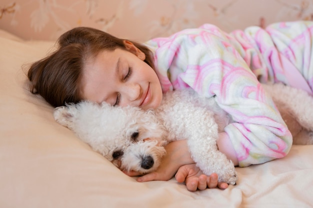 Free photo girl hugging her dog in the bed while sleeping