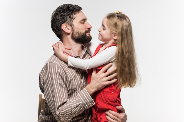 Free photo girl hugging her father  over a white wall