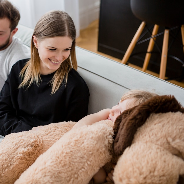 Girl hugging toy near parents