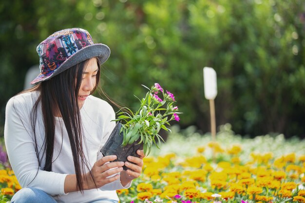 The girl is admiring the flowers in the garden.