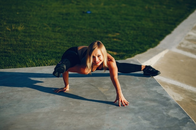 Girl is engaged in morning exercise in the park.