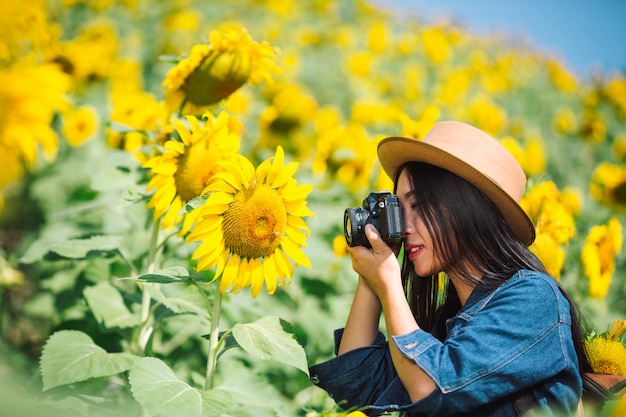 Free photo the girl is happy to take pictures in the sunflower field.