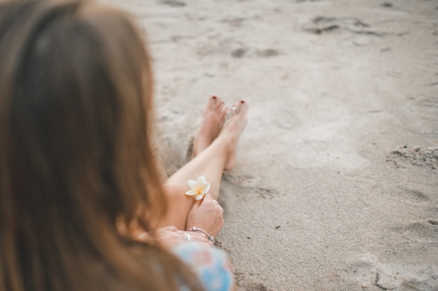 the girl is sitting on the beach