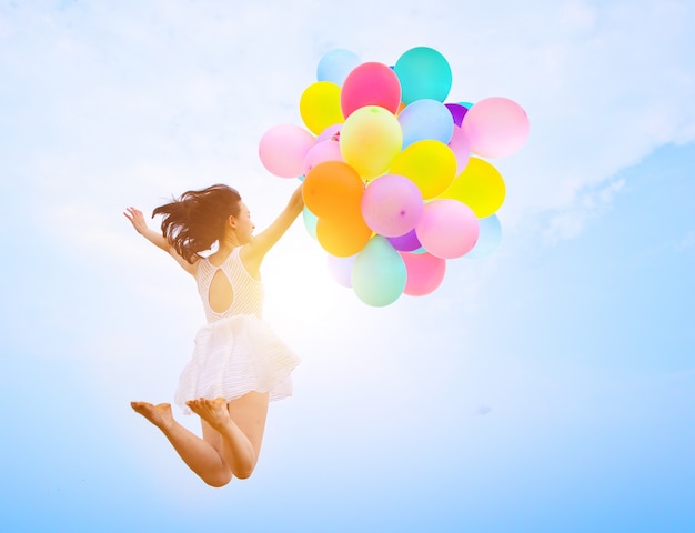 Girl jumping with balloons