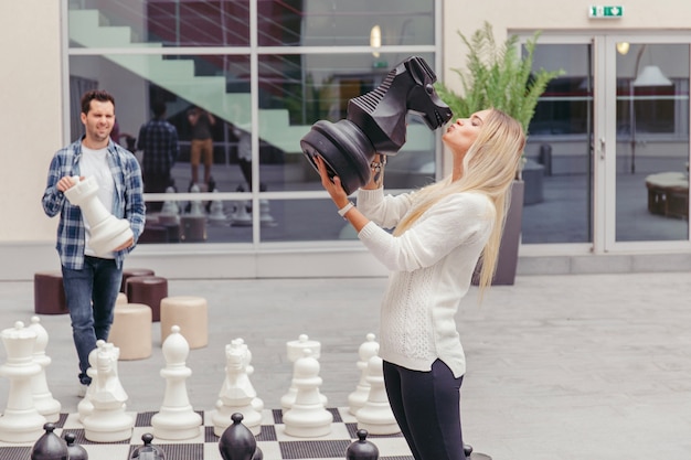 Free Photo girl kissing chess horse by chess board