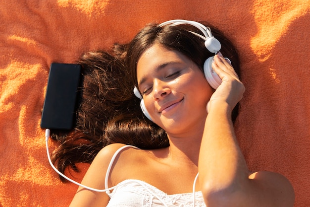 Girl laying on cloth with headphones