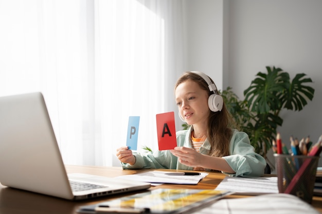 Free photo girl learning with laptop side view