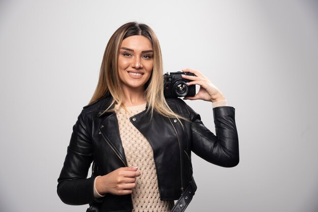 Girl in leather jacket taking her photos in elegant and positive positions.