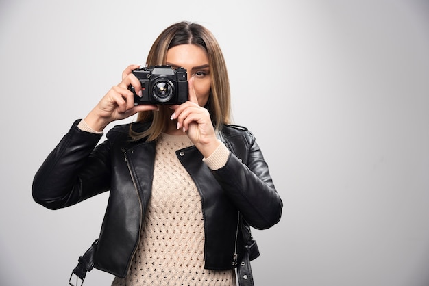 Girl in leather jacket taking her photos in elegant and positive positions