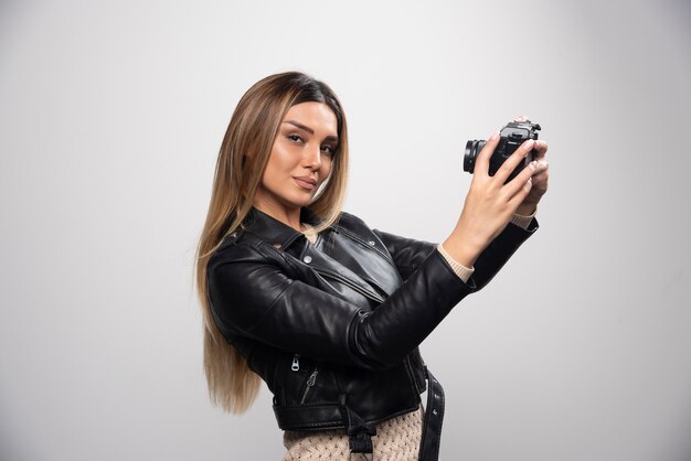 Girl in leather jacket taking her photos in elegant and positive positions