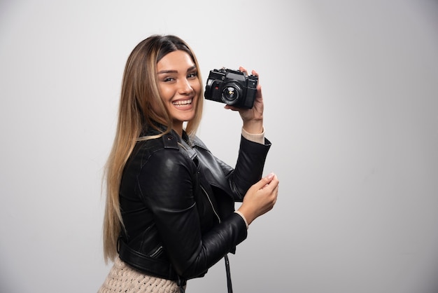 Girl in leather jacket taking her photos in elegant and positive positions