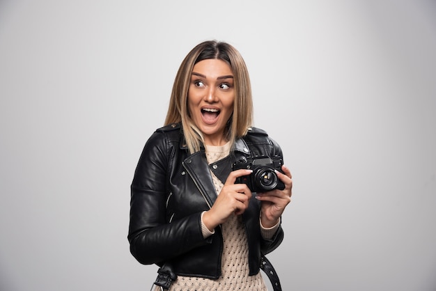 Girl in leather jacket taking her photos in funny and strange positions