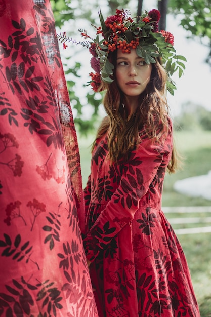 Free photo girl in a linen dress. with a wreath of flowers on her head.