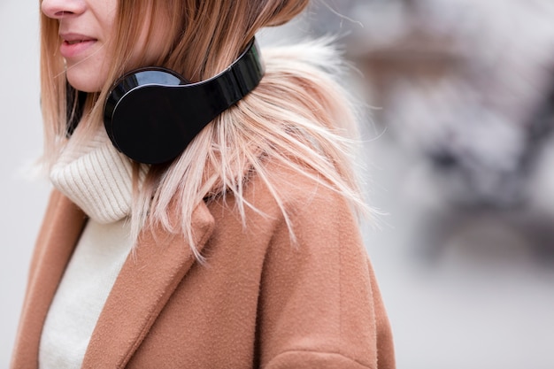 Girl listening to music on headphones close-up