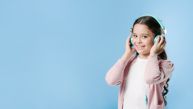 Girl listening to music with headphones in studio