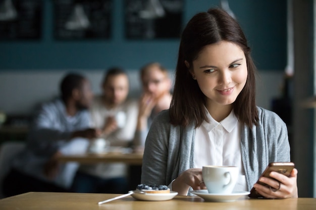 Girl looking at dessert ordered by guys flirting in cafe